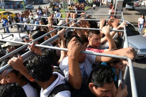 Pasajeros abordan camiones para trasladarse a sus lugares de trabajo o estudio, el 29 de julio de 2015 en San Salvador (AFP | Marvin Recinos)
